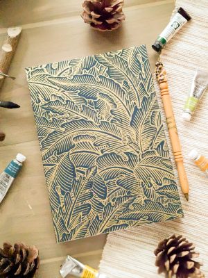 Photo du carnet "Eclat sauvage" de la collection de carnets Les Confidents "Douce nuit". Couverture bleu avec des feuillages dorés.